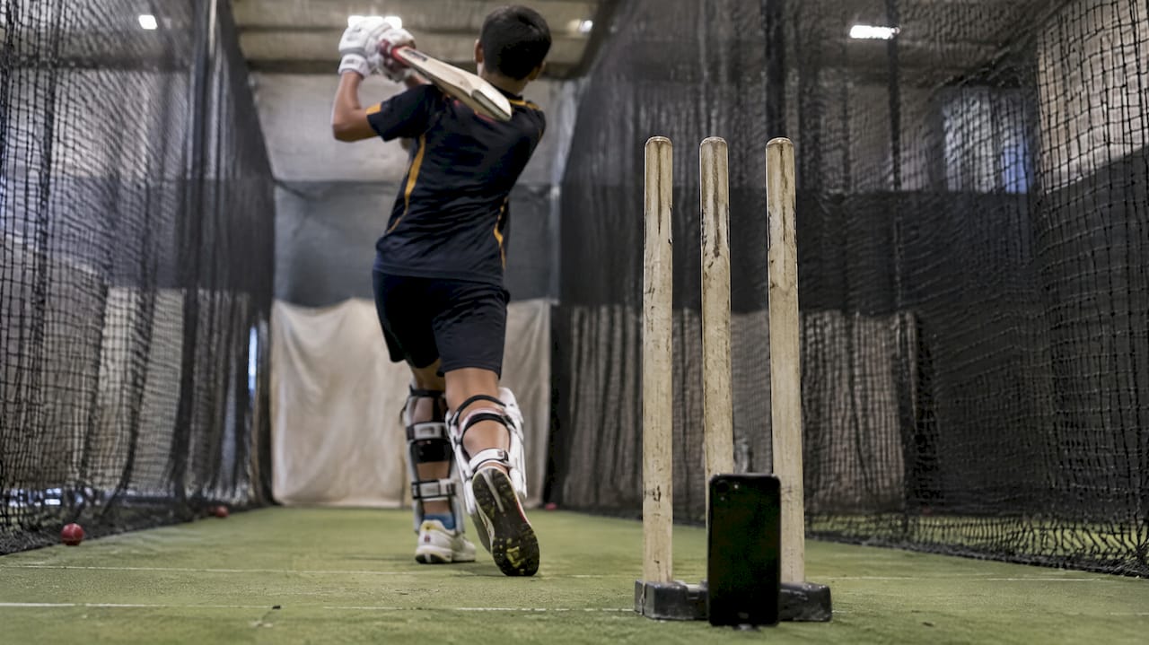 5 Research Backed Power Hitting Drills for Batters That Add Bat Speed Batter filming swing behind stumps