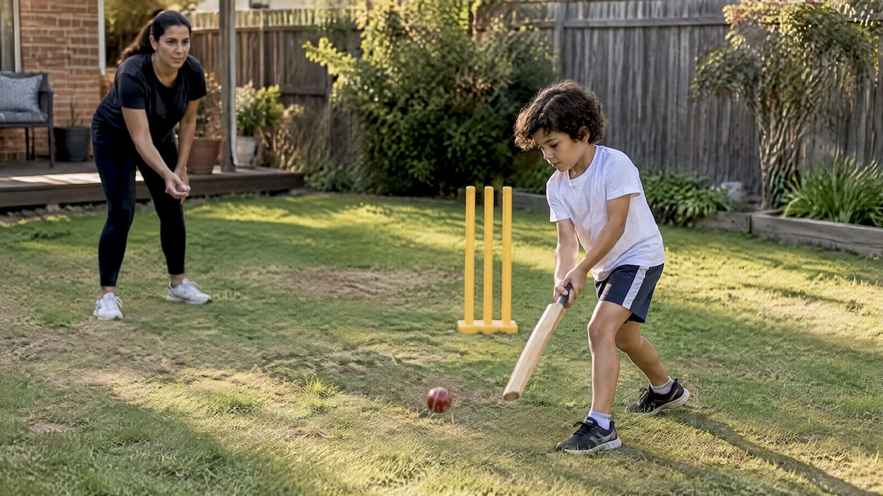 Parent and child playing backyard cricket