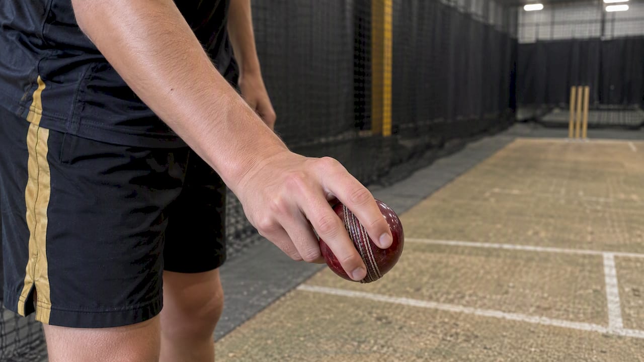 Bowler demonstrating cricket ball seam grip